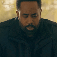 a man with a beard is wearing a black jacket with saint pierre written in the corner