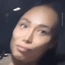 a blurry picture of a woman 's face with her eyes closed .