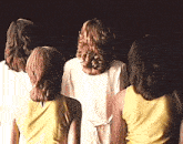 a group of women are standing next to each other and their backs are shown