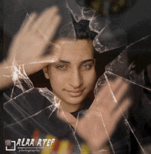 a young man behind a broken glass with alaa atef photography