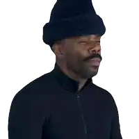 a man wearing a hat and a black jacket says " okay wait "