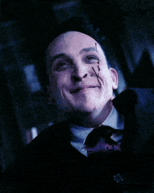 a man in a suit and tie is laughing with blood coming out of his eyes