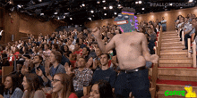 a man without a shirt is dancing in front of a crowd with the hashtag #fallontonight