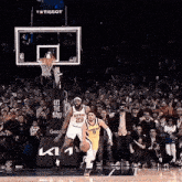 a basketball game is being played in front of a tissot banner