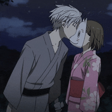 a man and a woman kissing with a mask on their face