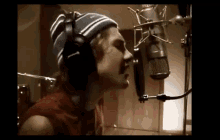 a man singing into a microphone with headphones on