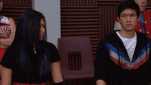 a man and a woman are sitting next to each other with a cheerleader wearing a chicago bulls jersey behind them