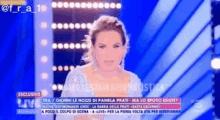 a woman in a white dress is talking on a television screen