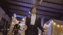 a man in a tuxedo holding a woman 's hand