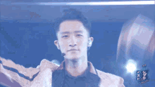 a man is standing on a stage with a microphone and a sign that says nhk