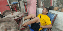 a man in a yellow shirt is sitting on a chair