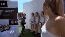 a group of women are standing in front of a sign that says lg grand prix of europe