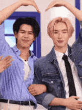 two men are making a heart shape with their arms