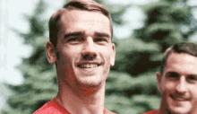 a close up of a man 's face with trees in the background .