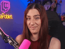 a woman holding a pink microphone in front of a neon sign that says apoblet