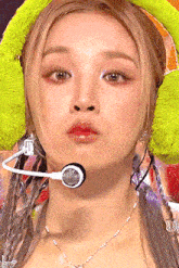 a close up of a woman wearing a microphone and ear warmers