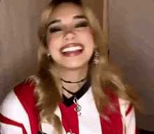 a close up of a woman wearing a red and white striped shirt and smiling .