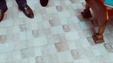 a person is standing on a tiled floor next to a mirror with the letter u on it