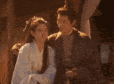 a man and a woman are sitting next to each other and hugging .