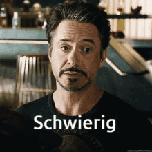 a man with a beard is wearing a shirt that says schwierig on it