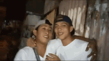 two young men are posing for a picture together and smiling .