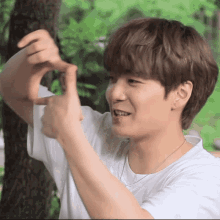 a young man making a heart shape with his fingers