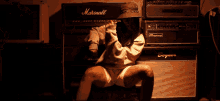 a woman is screaming in front of a marshall amp