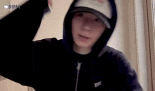 a close up of a person wearing a hoodie and a hat .
