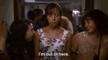a woman in a floral dress says i 'm out of here while standing next to two other women