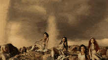 a group of women sitting on a rocky hillside