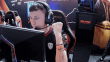 a man wearing headphones sits in front of a computer with a sign that says hal 3000