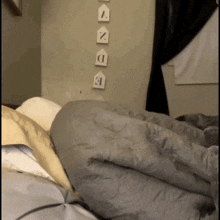 a bed with a blanket on it and a wall with a few signs on it