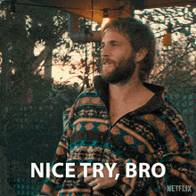 a man with a beard is wearing a colorful jacket and says nice try bro