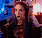 a woman with purple hair wearing headphones and a black top