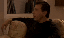 a man is sitting on a couch and says wink wink