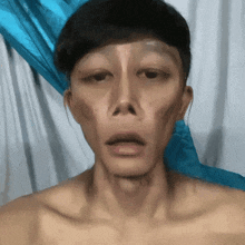 a man without a shirt is looking at the camera with his mouth open