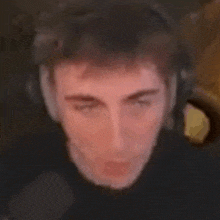 a man is making a funny face with his eyes closed .
