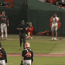 a woman in a red dress is kneeling on the baseball field