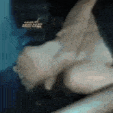 a close up of a person holding another person 's hand in a dark room .