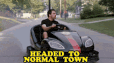a man is driving a go kart with the words headed to normal town behind him