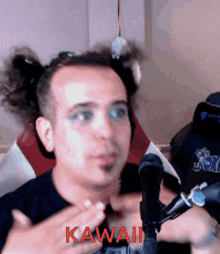 a man with pigtails is sitting in front of a microphone with the word kawaii in red