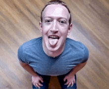 a man in a blue shirt is sticking out his tongue
