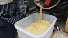 a person pouring dough into a plastic container that says made in animotica on the bottom