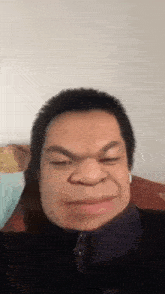 a man wearing headphones is making a funny face while sitting on a bed .