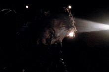 a man in a dark room with a light coming out of his head