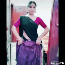 a woman in a purple skirt and a black top is standing in a room .