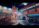a group of women are dancing in front of a building that says maldoong donut