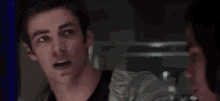 a close up of a man 's face looking at another man in a dark room .