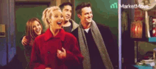 a group of people are standing next to each other in a room and laughing .