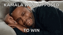 a man is laying on a couch with his eyes closed and crying because kamala was supposed to win .